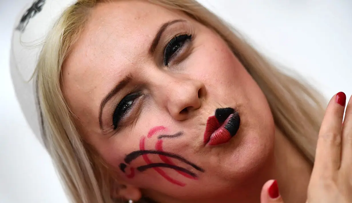Dengan mewarnai wajahnya wanita cantik Albania mendukung negaranya saat laga Grup A Piala Eropa 2016 di Stade Velodrome, Prancis, Kamis (16/6/2016). (AFP/Franck Fife)