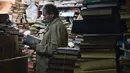 Jose Alberto Gutierrez memeriksa koleksi buku-bukunya di perpustakaan yang ada di lantai satu rumahnya di Bogota, Kolombia, 18 Mei 2017. Pria 54 tahun tersebut telah mengumpulkan buku buangan atau bekas sejak 20 tahun lalu. (GUILLERMO LEGARIA/AFP)