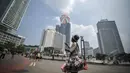 Pedagang parasut mainan saat menerbangkan barang dagangannya di kawasan Bundaran HI, Jakarta, Minggu (22/3/2015).  Seiring dengan perkembangan zaman dan modernisasi, permainan tradisional kini mulai tergantikan. (Liputan6.com/Faizal Fanani)