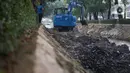 Petugas Sudin SDA Setiabudi menggunakan alat berat untuk mengeruk lumpur yang mengendap di Kali Minangkabau, Jakarta, Kamis (2/7/2020). Pengerukan dilakukan guna mengembalikan kedalaman kali sehingga memerlancar aliran air. (Liputan6.com/Immanuel Antonius)