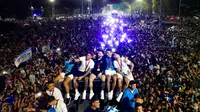 Lionel Messi dan kawan-kawan melakukan swafoto di atas bus saat parade juara Piala Dunia di kota Buenos Aires, Selasa (20/12/2020). (AFP/Tomas Cuesta)