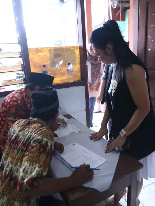 Meski berangkat bersama keluarga, KD berbeda TPS dengan mamanya. Pelantun lagu Menghitung Hari itu terlihat antusias datang ke TPS. Dengan busana putih dan berbalut blazer hitam.  (Nurwahyunan/Bintang.com)