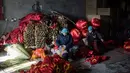 Pekerja membuat rumbai-rumbai untuk lampion merah yang akan dijual menyambut perayaan Tahun Baru Imlek di provinsi Hebei, Tingkok (11/1). (AFP Photo/Fred Dufour)