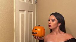 Beby Tsabina berpose sambil memegang mainan buah labu ciri khas Halloween. Beby tampil dengan aura yang menyeramkan. (Instagram/bebytsabina)