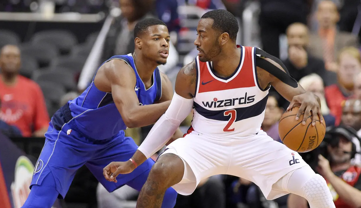 Pebasket Dallas Mavericks, Dennis Smith Jr, menjaga pebasket Washington Wizards, John Wall, pada laga NBA di Capital One Arena, Selasa (7/11/2017). Mavericks menang 113-99 atas Wizards. (AP/Nick Wass)