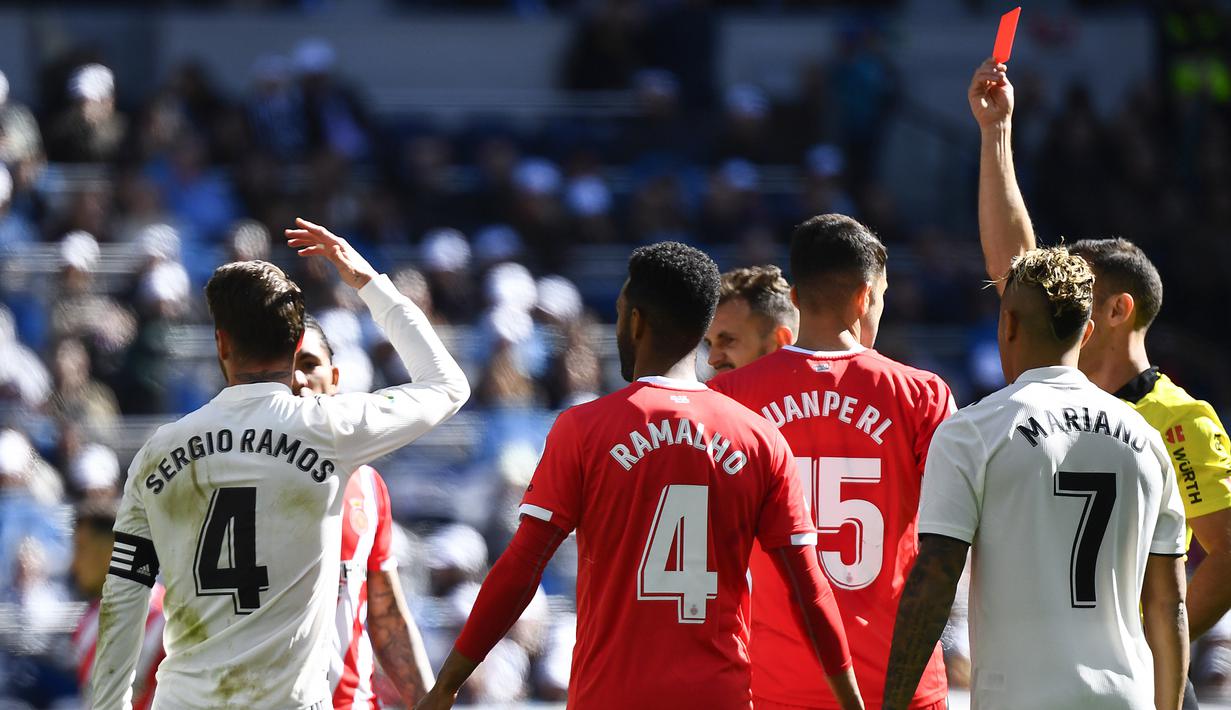 Wasit Guillermo Cuadra, memberikan kartu merah kepada kapten Real Madrid, Sergio Ramos, saat melawan Girona pada laga La Liga di Stadion Santiago Bernabeu, Madrid, Minggu (17/2). Madrid kalah 1-2 dari Girona. (AFP/Gabriel Bouys)