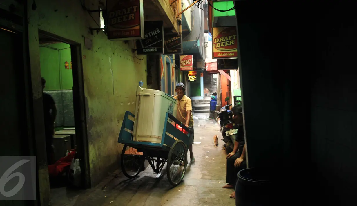 Seorang warga mengangkut perabot miliknya dari rumah yang akan dibongkar di kawasan Kalijodo, Jakarta, Kamis (18/2). Gubernur DKI hari ini mengirim SP 1 kepada warga untuk mengosongkan dan membongkar sendiri rumah mereka. (Liputan6.com/Gempur M Surya)