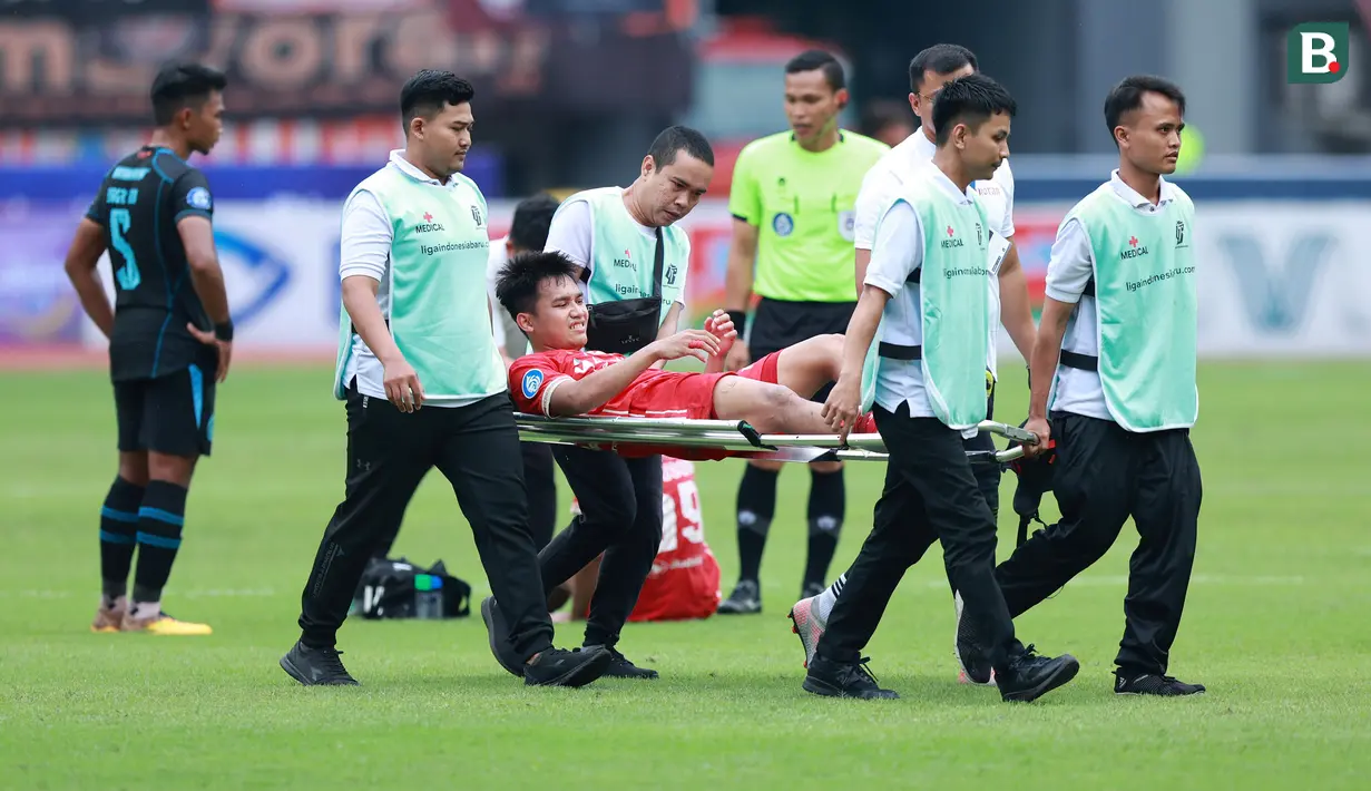 Pemain Persija Jakarta, Witan Sulaeman diangkat keluar lapangan setelah mengalami cedera saat melawan Arema FC dalam laga pekan ke-23 BRI Liga 1 2022/2023 di Stadion Patriot Candrabhaga, Bekasi, Minggu (12/2/2023) sore WIB. Persija menang dengan skor 2-0. (Bola.com/M Iqbal Ichsan)
