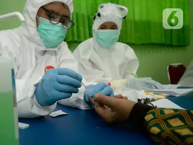 Petugas melakukan pemeriksaan cepat COVID-19 (Rapid Test) kepada tenaga pendidik SMP di SMPN 3 Ciputat, Tangerang Selatan, Kamis (27/08/2020). Rapid tes yang diikuti 400 guru mencakupi wilayah Ciputat dan Ciputat Timur itu untuk mencegah penyebaran Covid-19 di lingkungan pendidikan. (merdeka.com/Dwi