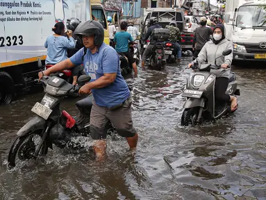 Sejumlah kendaraan menerobos banjir yang menggenangi jalan raya Kamal, Cengkareng, Jakarta Barat, Kamis (30/1/2025). (Liputan6.com/Angga Yuniar)