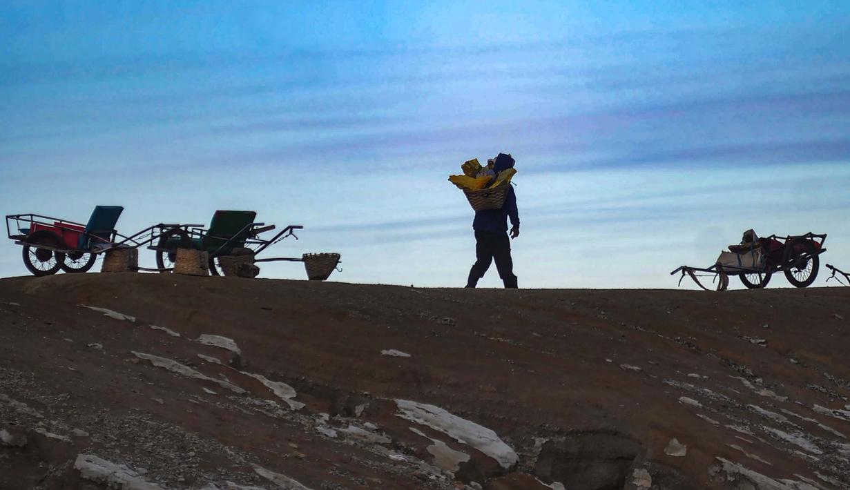 Dengan keindahan alam, fenomena unik, serta tantangan pendakian yang ditawarkan, Kawah Ijen menjadi salah satu rekomendasi destinasi wisata alam yang menarik untuk dikunjungi, khususnya pada momen libur akhir tahun. Tampak dalam foto, penambang tradisional memikul bongkahan belerang di Gunung Ijen, Banyuwangi, Jawa Timur. (merdeka.com/Arie Basuki)