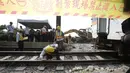Para pekerja memeriksa kereta yang tergelincir dekat Ngarai Taroko di Hualien, Taiwan, Sabtu (3/4/2021). Kereta 408 adalah salah satu yang tercepat dan dapat mencapai kecepatan 130 km/jam (80 mph). (AP Photo/Chiang Ying-ying)