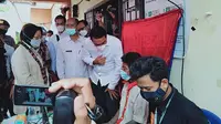 Menteri Sosial Tri Rismaharini (kiri) didampingi Bupati Batanghari (ketiga kanan) meninjau perekaman e-KTP orang rimba di Desa Jelutih, Kabupaten Batanghari, Jambi, Rabu (10/3/2021). Ribuan jiwa orang rimba di Jambi kini telah merekan data kependudukan. (Liputan6.com/Gresi Plasmanto)