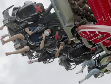 Pengunjung mengenakan masker saat menaiki rollercoaster Vortex di Siam Amazing Park, Bangkok, Thailand, Rabu (17/6/2020). Keseharian warga Bangkok berangsur normal setelah pemerintah terus melonggarkan pembatasan terkait pandemi virus corona COVID-19. (AP Photo/Sakchai Lalit)