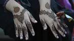 Seorang ahli kecantikan mengecat tangan pelanggan dengan henna tradisional untuk persiapan perayaan Lebaran Idul Fitri mendatang, di Karachi, Pakistan, Kamis, 20 April 2023. (AP Photo/Fareed Khan)