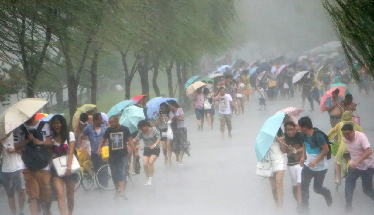 Sejumlah warga Taiwan berjalan melawan angin kencang saat badai Topan Soudelor mulai mendekati di Hangzhou, Zhejiang, Taiwan (7/8/2015). Ratusan warga dievakuasi karena topan terkuat dalam dua tahun terakhir mengancam wilayah tersebut.  (REUTERS/Stringer)