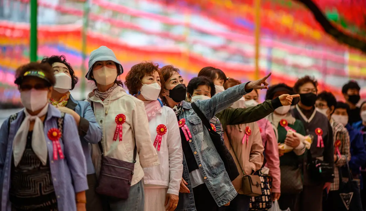 <p>Para jemaah berbaris untuk mencuci patung Buddha setelah kebaktian untuk merayakan ulang tahun Buddha di Kuil Jogye, Seoul, Korea Selatan, Minggu (8/5/2022). (ANTHONY WALLACE/AFP)</p>
