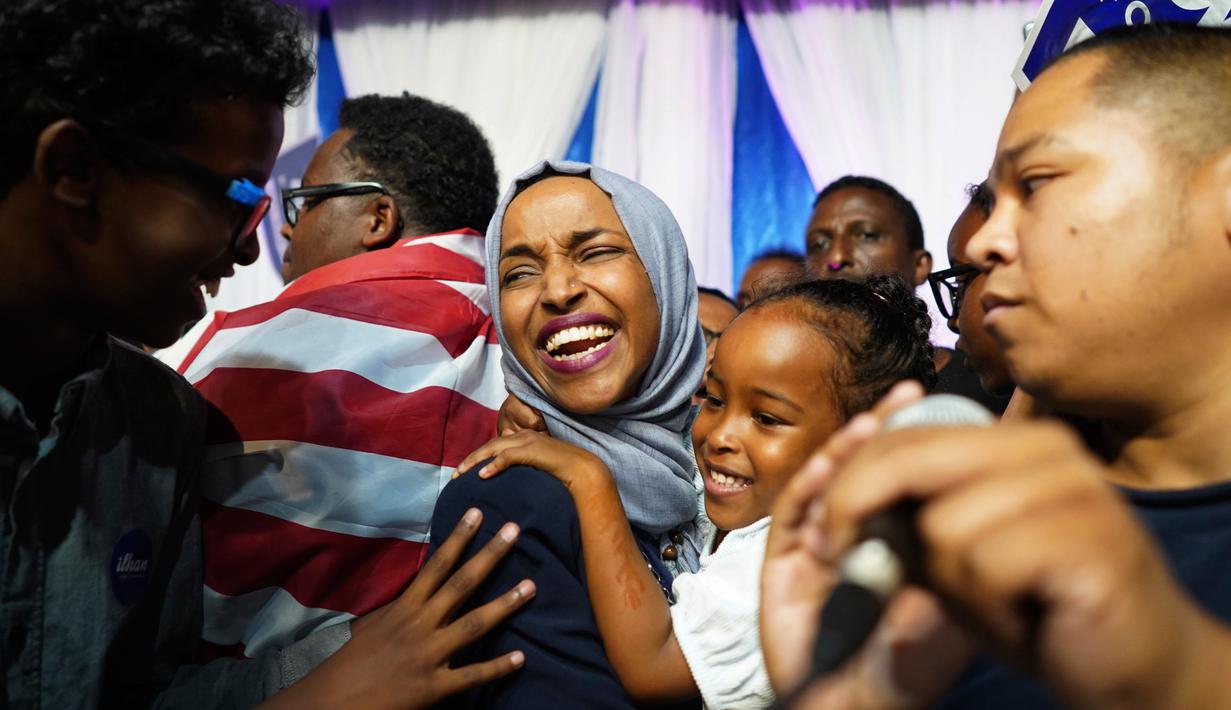 Ilhan Omar menggendong anaknya saat merayakan kemenangan pemilihan Distrik Kongres ke-5 di Minneapolis, AS, Selasa (14/8). Omar mencetak sejarah dengan memenangi putaran pertama pemilihan Distrik Kongres ke-5. (Mark Vancleave/Star Tribune via AP)