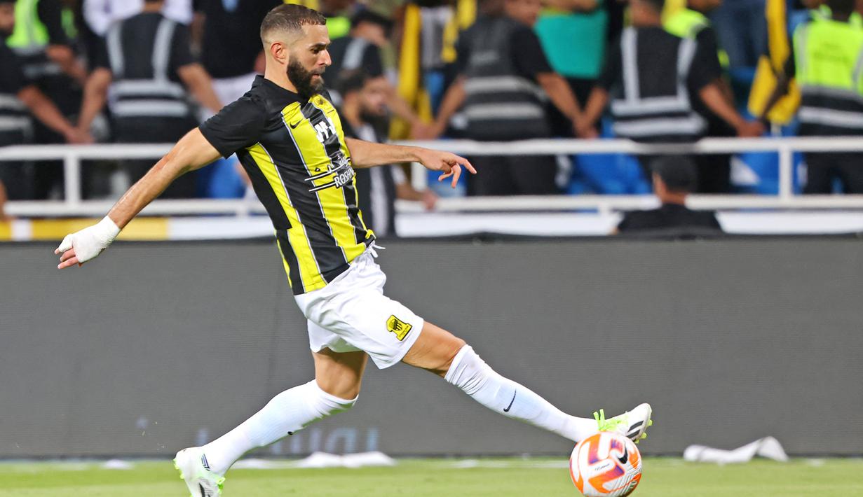 Pemain Al Ittihad, Karim Benzema, mengontrol bola saat melawan Al Riyadh pada laga pekan ketiga Liga Arab Saudi di Prince Faisal bin Fahd Stadium, Riyadh, Jumat (25/8/2023). Bermain selama 90 menit, Benzema tampil impresif dengan melepaskan dua tembakan yang satu di antaranya mengarah ke gawang, melakukan 54 sentuhan, dan akurasi umpan hingga 89 persen. (AFP/Fayez Nureldine)