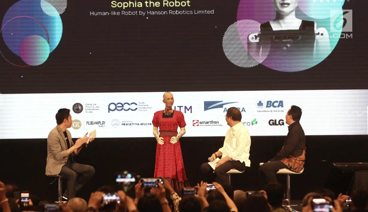 Menkominfo Rudiantara (dua kanan) didampingi Kepala Badan Ekonomi Kreatif Triawan Munaf (kanan) berinteraksi dengan robot Sophia dalam dialog internasional CSIS di Hotel Borobudur, Jakarta, Selasa (17/9/2019). Sophia merupakan produksi perusahaan asal Hong Kong. (merdeka.com/Iqbal Nugroho)