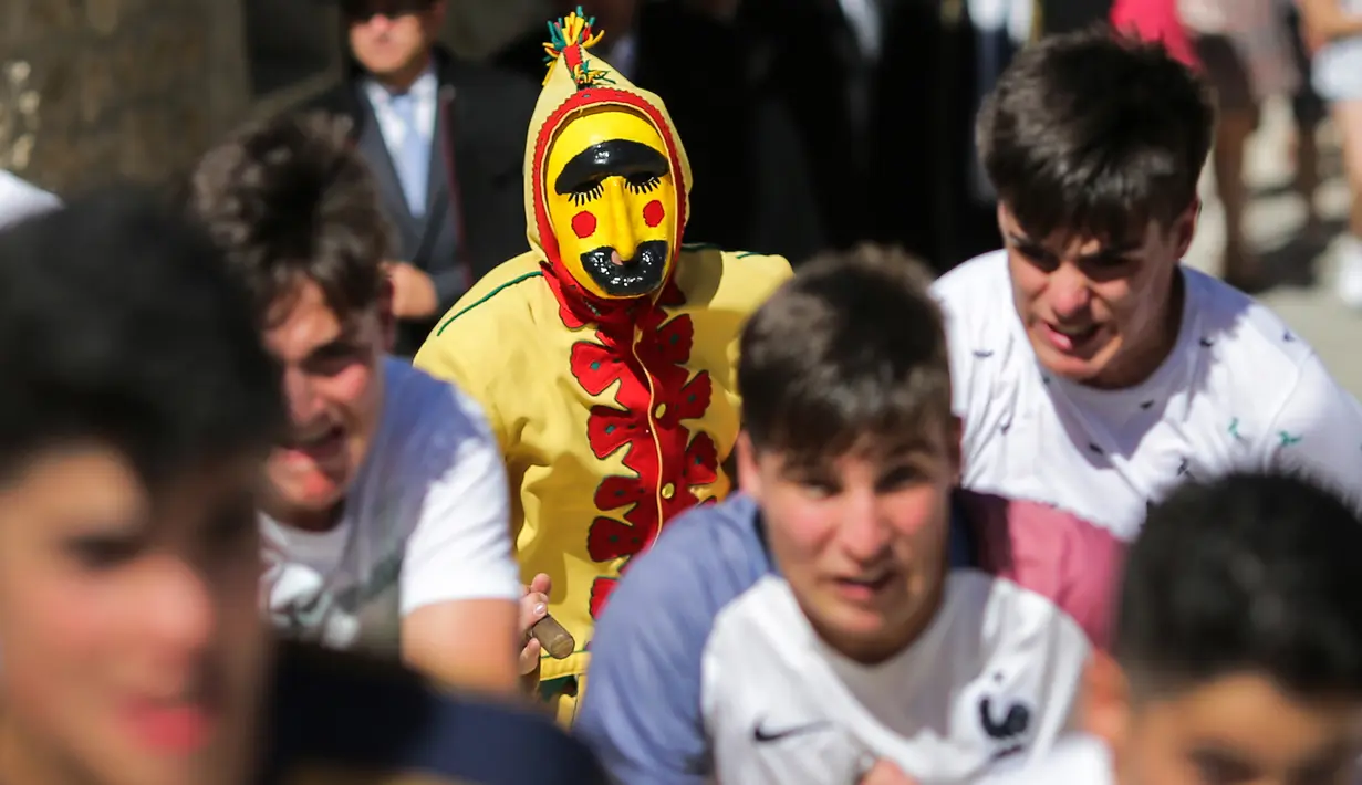 Pria berkostum setan mengejar kerumunan orang selama festival melompati bayi (El Colacho) di desa Castrillo de Murcia, Minggu (18/6). Festival ini dimulai ketika kerumunan orang termasuk para orang tua dari bayi-bayi  sudah berkumpul. (CESAR MANSO/AFP)