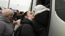 Seorang wanita mencium seorang anak ketika mereka mengantre untuk naik bus setelah meninggalkan Ukraina di perbatasan di Medyka, Polandia, 4 Maret 2022. (AP Photo/Markus Schreiber)