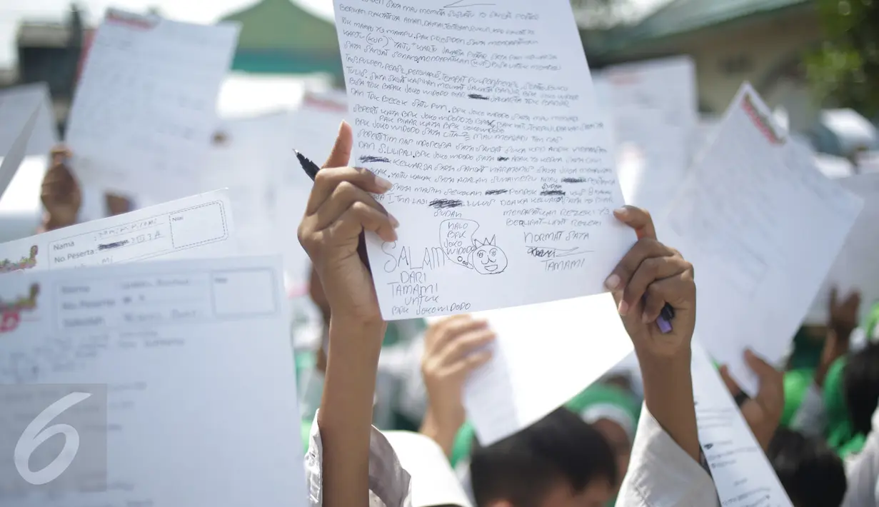 Murid MI Yayasan Nurul Bahri menunjukkan surat yang ditulis untuk Presiden Jokowi, di perkampungan nelayan Muara Angke, Jakarta, Senin (27/2). Kegiatan itu juga sebagai kepedulian pada dunia literasi untuk anak Indonesia. (Liputan6.com/Faizal Fanani)