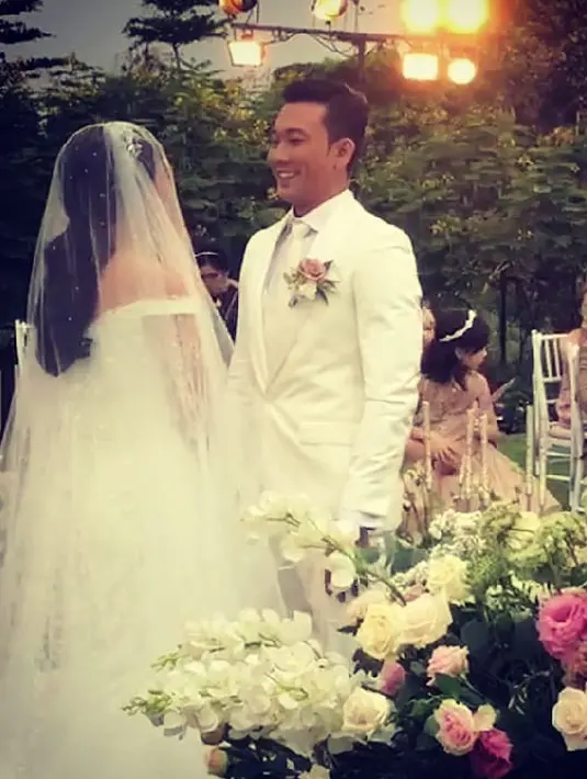 Momen sakral tersebut disiarkan secara Live di akun Instagram Denny. Pernikahan Densu dan Olivia kental bernuansa putih. Berlangsung di sore hari dan suasana outdoor serta berlatar pegunungan yang indah. (FOTO: Instagram)