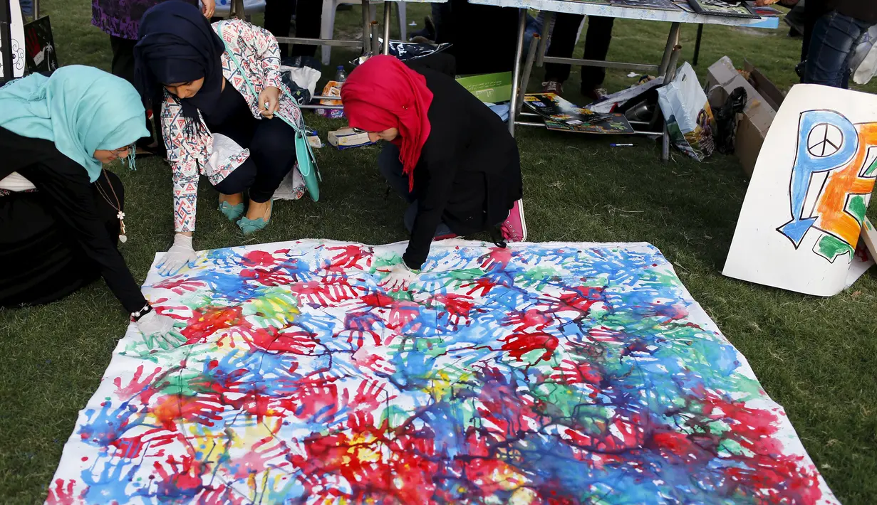 Tiga orang wanita Irak membuat karya seni lukisan abstrak dengan cetakan tangan selama Hari Perdamaian Internasional di Baghdad,Irak (21/9/2015). Perayaan diisi dengan kreativitas seni karya para pemuda dan pemudi Irak. (REUTERS/Thaier al-Sudani)