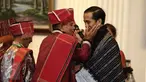 Pemangku Hutan Adat dari Tombak Haminjon (Kemenyan) Provinsi Sumatera Utara mengalungkan kain ulos kepada Presiden Joko Widodo (Jokowi) usai pencanangan pengakuan Hutan Adat di Istana Negara, Jakarta, Jumat (30/12). (Liputan6.com/Faizal Fanani)