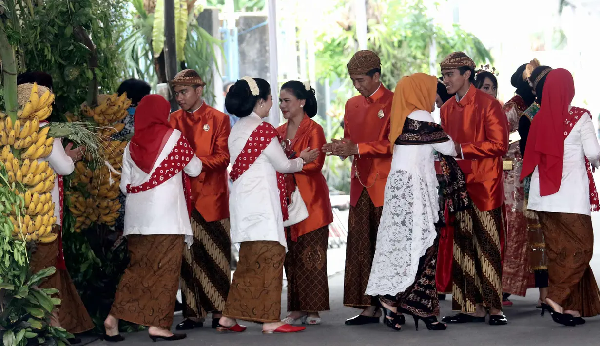 Presiden Joko Widodo (Jokowi) didampingi Ibu Negara, Iriana serta Gibran Rakabuming dan Kaesang Pangarep menyalami tamu yang pulang dari kediamannya di Jalan Kutai Utara, Solo usai prosesi siraman Kahiyang Ayu, Selasa (7/11). (Liputan6.com/Angga Yuniar)