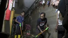 Para pria membersihkan sisa-sisa banjir di Badung, Bali, pada Jumat 12 September 2025. (AP Photo/Firdia Lisnawati)