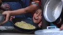 Sejumlah anak-anak ikut berdesakan sambil menggegam wadah untuk mendapatkan jatah makanan yang dibagikan. (BASHAR TALEB/AFP)