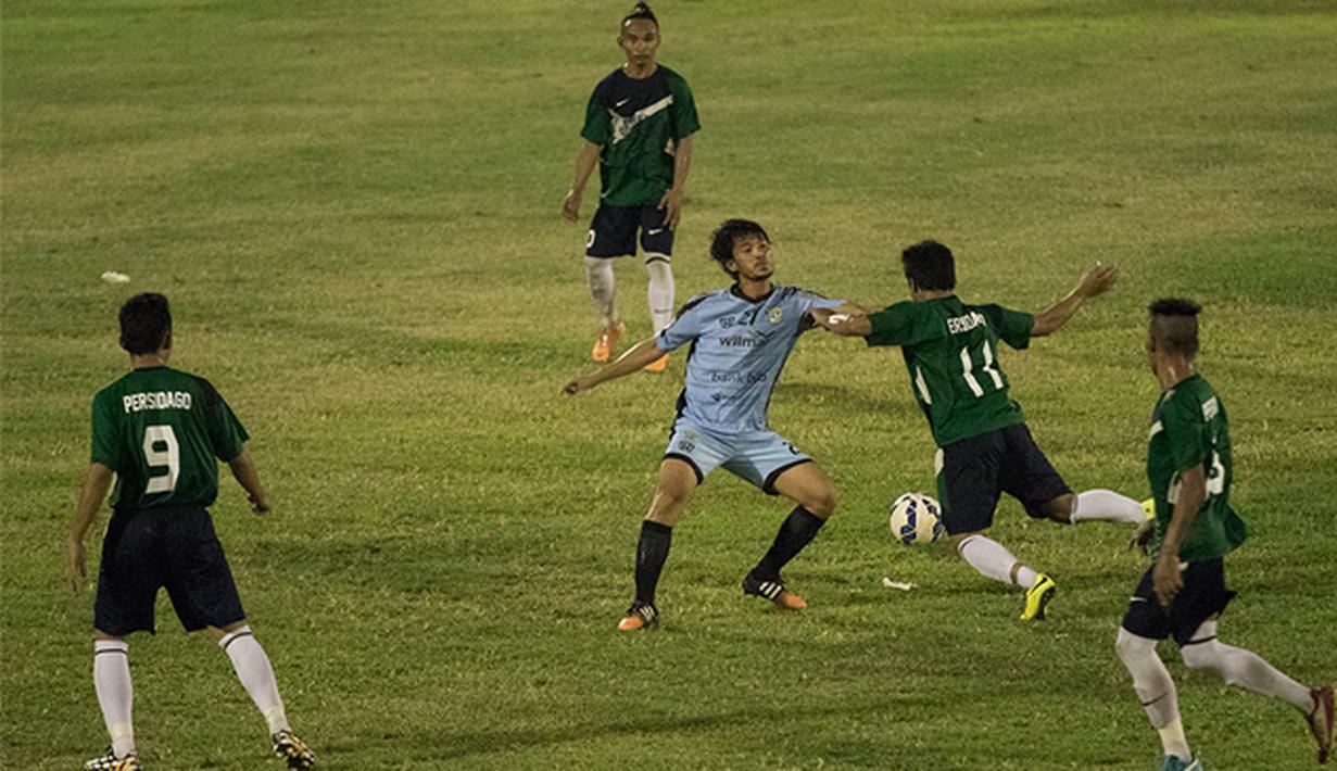 Pemain Perserang, Ade Suhendra berusaha menahan pergerakan dari pemain Persidago, Tri Herianto pada laga perdana Piala Kemerdekaan di Stadion Maulana Yusuf, Serang, Sabtu (15/8/2015). (Bola.com/Vitalis Yogi Trisna)