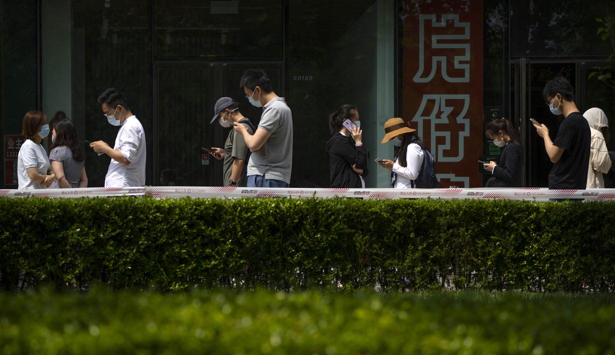 <p>Orang-orang antre tes COVID-19 di tempat pengujian virus corona di Beijing, Kamis (19/5/2022). Sebagian wilayah Beijing menghentikan pengujian massal harian yang telah dilakukan beberapa minggu terakhir, tetapi banyak tempat pengujian tetap sibuk karena syarat tes negatif COVID-19 dalam 48 jam terakhir untuk memasuki beberapa bangunan di ibu kota China. (AP Photo/Mark Schiefelbein)</p>