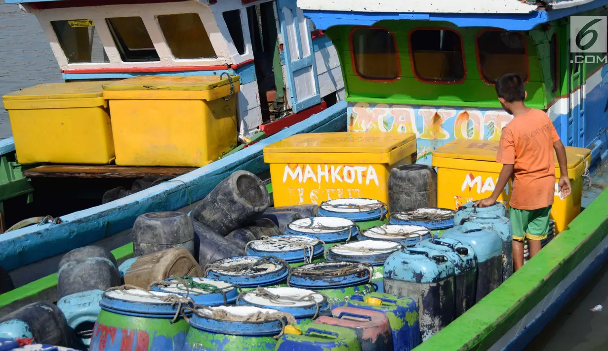 Seorang anak memeriksa air bersih dalam jiriken di atas perahu yang ada di Jakarta Utara, Rabu (9/5). Sulitnya mendapatkan air bersih memaksa nelayan membelinya kepada pengepul dengan harga yang mahal. (Liputan6.com/Angga Yuniar)