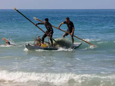 Nelayan Palestina mendayung di pantai Deir el-Balah, di Jalur Gaza Tengah pada 30 November 2023. (Mahmud Hams/AFP)