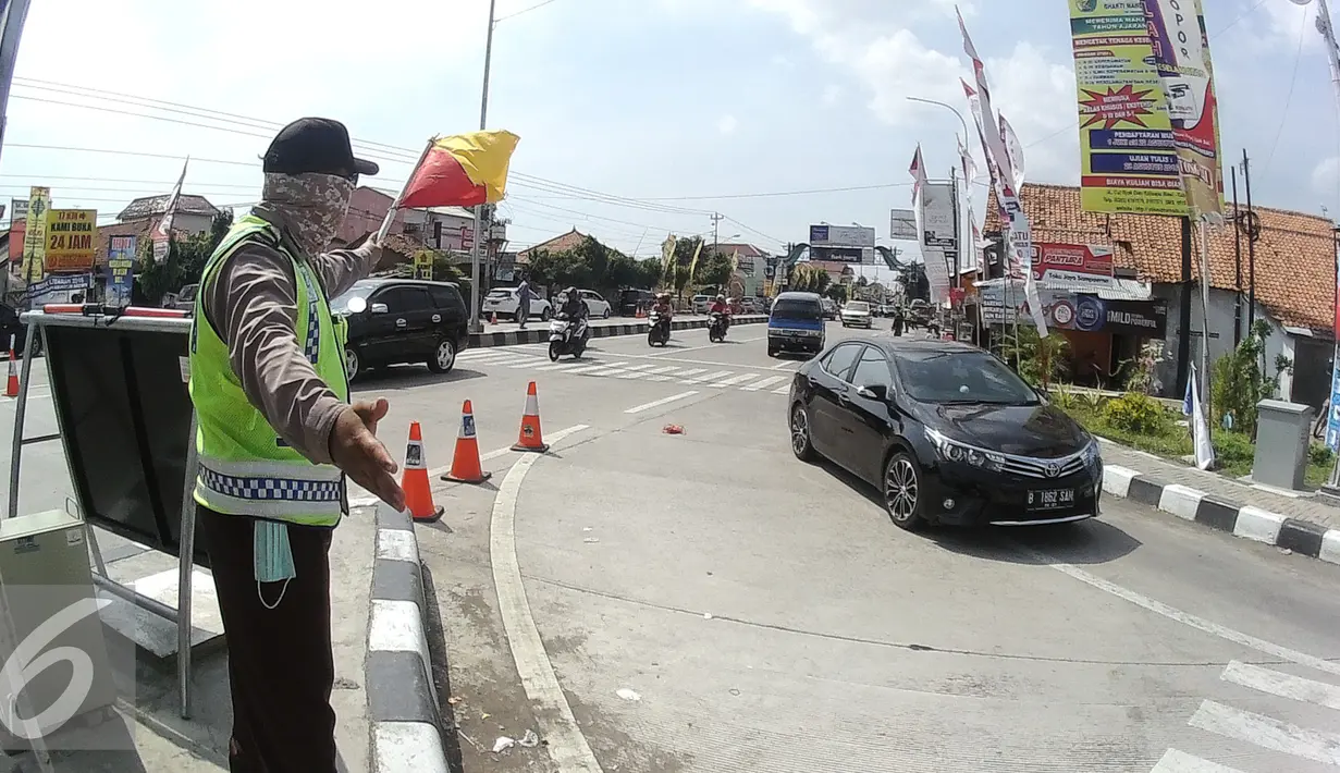 Petugas sedang mengatur lalu lintas di pertiga exit tol brebes timur - Pantura, Jawa Tengah, Sabtu (9/7). H+3, dari exit tol Brebes timur telah diberlakukan contra flow sampai km 267. (Liputan6.com/Herman Zakharia)