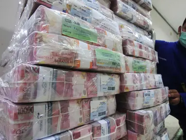 Petugas merapikan uang di Kantor Kas Bank Mandiri, Jakarta, Senin (4/1/2016). Nasib rupiah di tahun 2016 sulit menguat di tengah tingginya permintaan dollar. (Liputan6.com/Angga Yuniar)