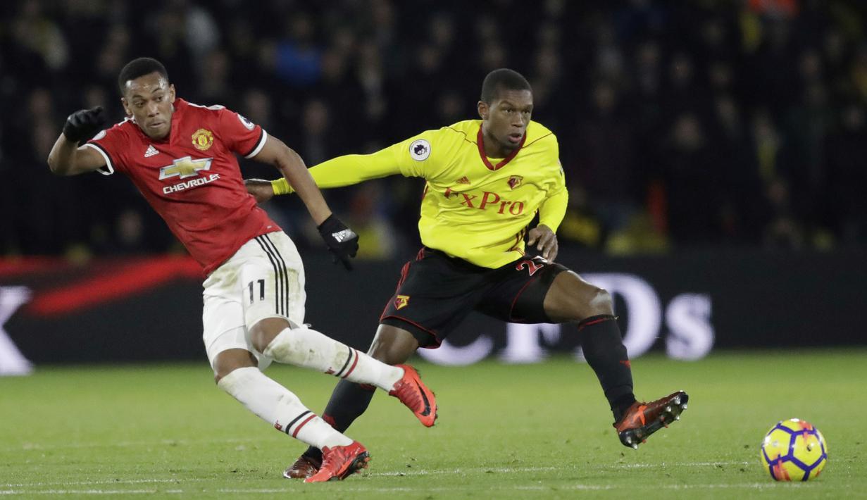 Aksi pemain Manchester United, Anthony Martial melepaskan tembakan melewati adangan pemain Watford, Christian Kabasele(kanan) pada lanjutan Premier League di Vicarage Road stadium, Watford, (28/11/2017). MU menang 4-2. (AP/Matt Dunham)