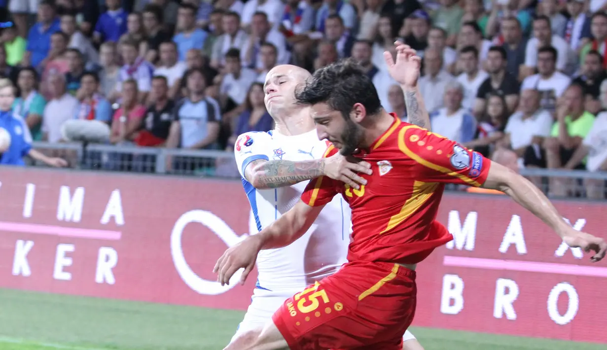 Gelandang bertahan Makedonia Dusko Trajkovski (merah) dihadang winger Slowakia, Vladimir Weiss. (Bola.com/Reza Khomaini)