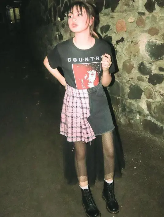 Tampil edgy, Zara memadukan printed t-shirt dengan two tone skirt. Penampilannya makin kece dengan sepatu boots.  (Instagram/zara_leola_official).