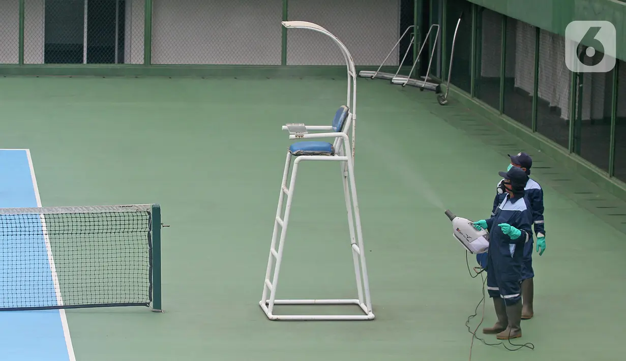 Petugas menyemprotkan cairan disinfektan pada area Lapangan Tennis Outdoor di Kompleks Olahraga GBK (Gelora Bung Karno), Senayan, Jakarta, Kamis (19/3/2020). Penyemprotan untuk mencegah penyebaran Virus Corona Covid-19 di Lingkungan Kompleks Olahraga GBK. (Liputan6.com/Herman Zakharia)