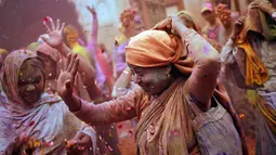 Seorang janda menari mengikuti tradisi perayaan Holi di Vrindavan, Uttar Pradesh, India (21/3). Sebelumnya para janda dilarang mengkuti tradisi ini karena dianggap buruk oleh masyarakat Hindu di India. (REUTERS/Anindito Mukherjee)