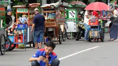 Pedagang kaki lima menjajakan makanan dan minuman di sisi jalan sekitar kawasan Patung Kuda Jakarta, Rabu (5/1/2019). Mereka mencoba peruntungan saat para buruh melakukan aksi perayaan Hari Buruh International atau May Day. (Liputan6.com/Helmi Fithriansyah)