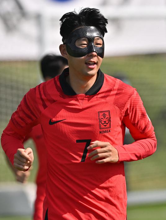 Kapten timnas Korea Selatan Son Heung-min mengenakan masker pelindung saat mengikuti sesi latihan menjelang dimulainya Piala Dunia 2022 Qatar, di Al Egla Training Site 5 di Doha, Rabu (16/11/2022). Cedera wajah sempat membuat cemas akan keikutsertaan Son Heung-min di Piala Dunia 2022 apalagi dia memutuskan untuk naik meja operasi. (Jung Yeon-je / AFP)