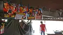 Seorang pria berjalan ke luar bioskop darurat di bawah jembatan di India (25/5). Untuk menghibur warga kurang mampu yang menyukai musik dan film Bollywood, tempat ini menayangkan sebanyak 4 film dalam sehari. (REUTERS/Cathal McNaughton)