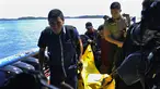 Anggota kepolisian bersiap turun dari kapal sambil mengangkat kantong jenazah berisi puing-puing dan barang-barang dari jatuhnya pesawat jenis M-28 Skytrcuk milik Polri di Pelabuhan Telaga Punggur, Batam, Kepri, Minggu (4/12). (Rezza HERDIYANTO/AFP)