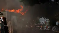 Kebakaran melanda sedikitnya lima gudang toko material di Jalan Joglo Raya, Jakarta Barat, Kamis (21/5/2015) siang sekitar pukul 15.00 WIB. Menurut warga sekitar, api diduga muncul dari lantai dua gudang toko material. (Liputan6.com/Helmi Afandi)
