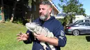 Seorang petugas menemukan iguana yang kaku kedinginan di Taman Nasional Everglades, Florida selatan, 6 Januari 2018. Sejumlah hewan ikut merasakan temperatur dingin ekstrem yang tengah melanda pesisir timur Amerika Serikat. (AP Photo)